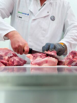 A butcher slices cuts of pork at the currywurst sausage production line in the Volkswagen AG (VW) manufacturing plant in Wolfsburg, Germany. Photographer: Krisztian Bocsi/Bloomberg